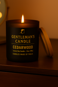 Gentleman's Candle Cedarwood on a wooden surface with a warm glow.
