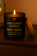Gentleman's Candle Sweet Tobacco on a wooden surface with a warm glow.