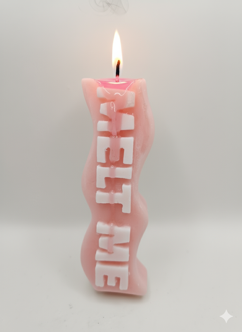 Pink Melt Me specialty slogan candle with white text, handmade soy wax candle lit with warm glow

