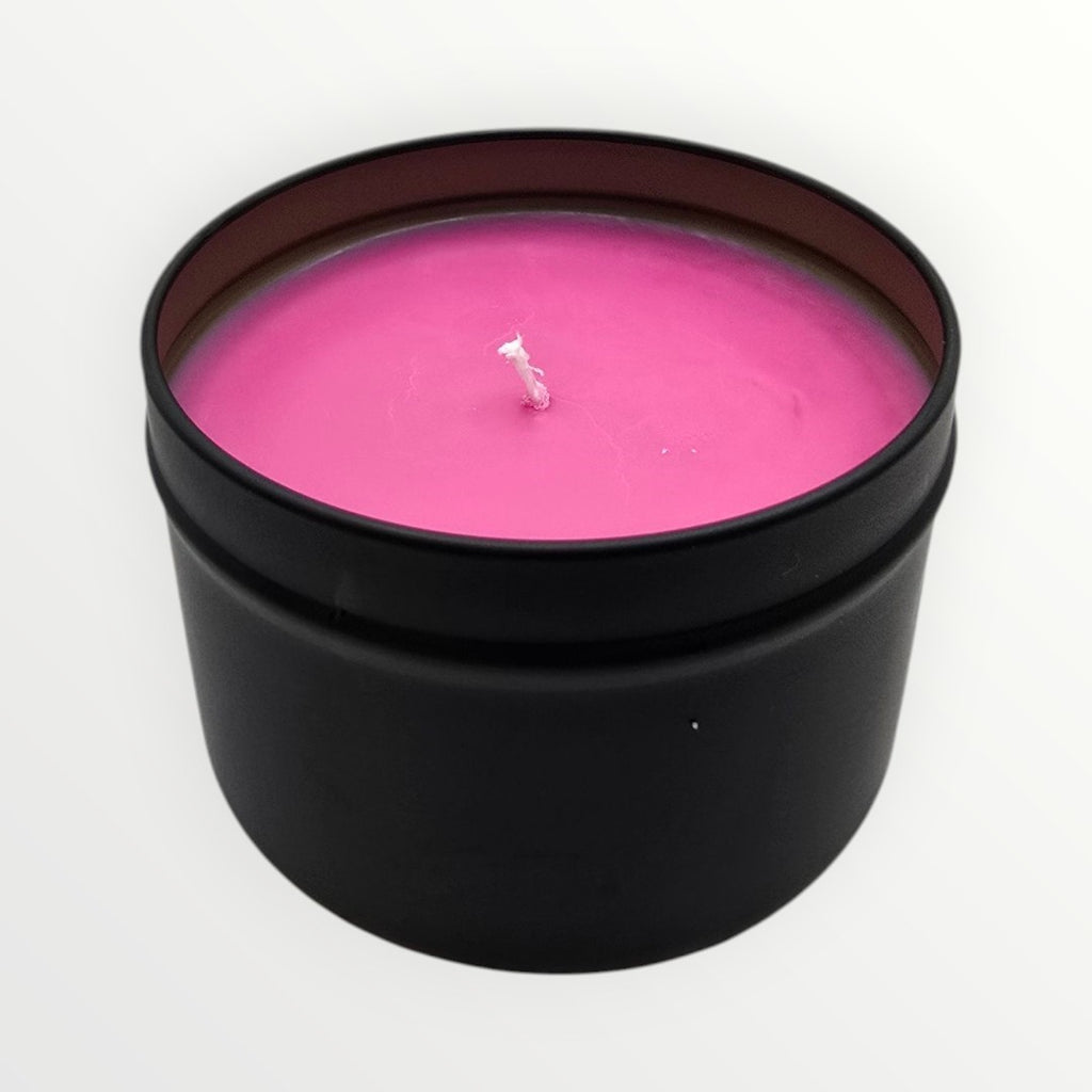 Pink candle in a black container on a white background
