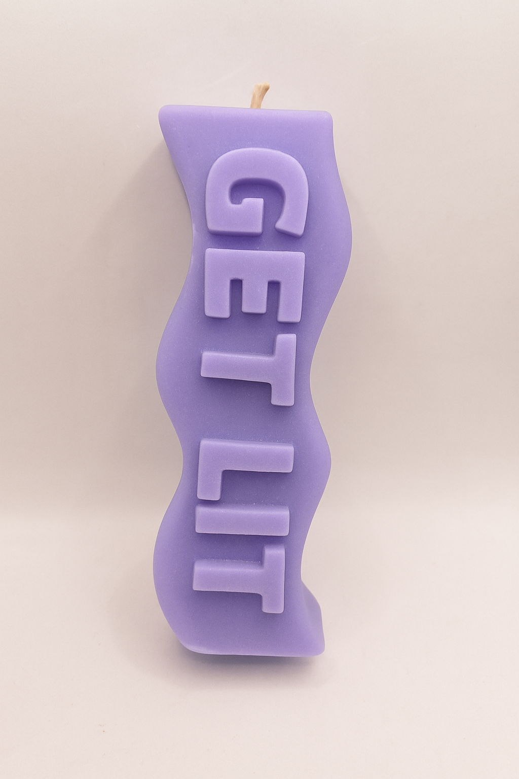 Purple candle shaped like the word 'GET LIT' on a beige background